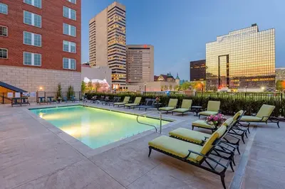 a swimming pool with lounge chairs and a city skyline at The KING Apt in Downtown Columbus in Columbus