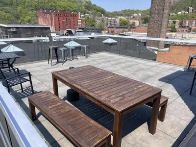 a wooden table and benches on a roof at BUBBLES FANTASY SUITE Explore OTR and Rhinegeist in Cincinnati