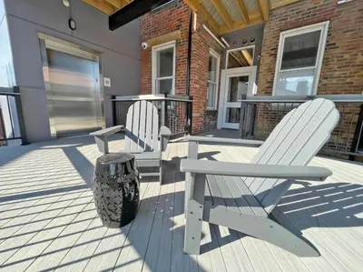two white chairs sitting on a porch with a trash can at Findlay Suites - Perfect Location Over the Rhine in Cincinnati