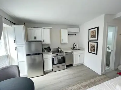 a kitchen with white cabinets and a stainless steel refrigerator at Full Building Huge Downtown Retreat Walkable to Everything in Cincinnati