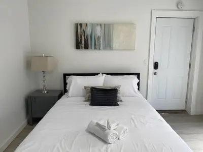 a white bed with two towels on top of it at Cute Microapartment Walkable to Everything in Cincinnati