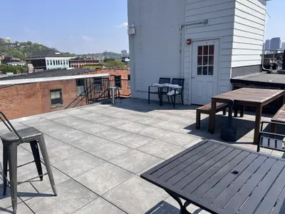 a patio with tables and benches on a building at SWIZZLE Explore OTR and Downtown from Rhinegeist in Cincinnati