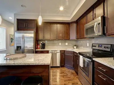 a kitchen with wooden cabinets and stainless steel appliances at Two Comfy Condos Near City Center OTR UC Zoo in Cincinnati