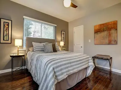 a bedroom with a bed and two lamps and a window at Two Comfy Condos Near City Center OTR UC Zoo in Cincinnati