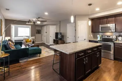 an open kitchen and living room with a couch at Two Comfy Condos Near City Center OTR UC Zoo in Cincinnati