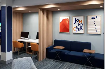 a waiting room with a couch and a desk with a laptop at Holiday Inn Express & Suites Lima by IHG in Lima