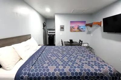 a bedroom with a bed and a tv on the wall at Hillsboro Inn & Suites in Hillsboro