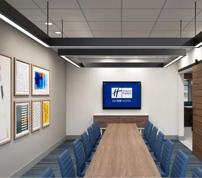a conference room with a tv and blue chairs at Holiday Inn Express & Suites Columbus - New Albany by IHG in New Albany