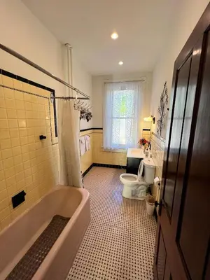a bathroom with a tub and a toilet at Skyline Retreat Spacious Elegance Queen Suite 1 City Views in Cincinnati
