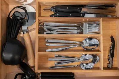 a wooden drawer filled with silver utensils at OTR, QUEEN Bed, 50in TV, Workspace, Near Lightrail in Cincinnati