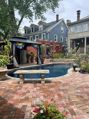 a swimming pool with a bench in front of a house at Mike & Allen's Place on the Park_2 in Columbus