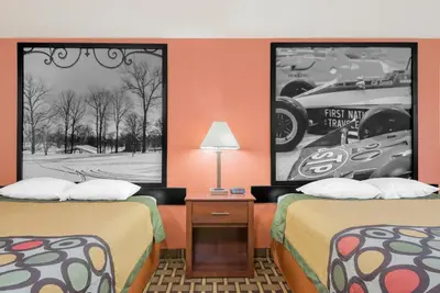 two beds in a motel room with two posters at Super 8 by Wyndham Shelbyville in Shelbyville