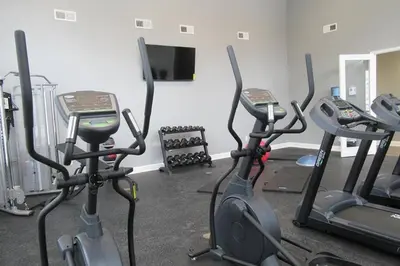 a gym with three exercise bikes and a flat screen tv at Luxury 1BR/1BA w/ Top Amenities in Prime Location in Fort Wayne