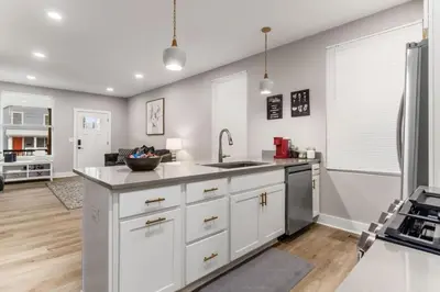 a kitchen with white cabinets and a sink at Entire Home Private Parking Fenced Yard in Columbus