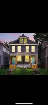 a large house with a clock on top of it at 2 homes side by side downtown with fenced yard and hot tub in Columbus