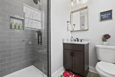 a bathroom with a shower and a toilet and a sink at Massive home downtown with Hot Tub in Columbus