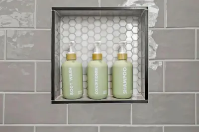 three green bottles sitting on a shelf in a bathroom at Massive home downtown with Hot Tub in Columbus