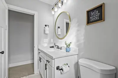 a white bathroom with a sink and a mirror at Massive home downtown with Hot Tub in Columbus