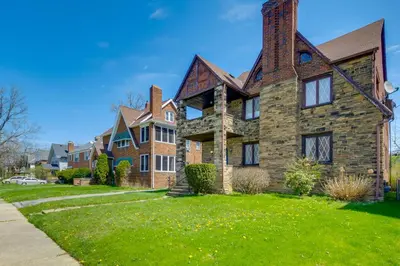 a large brick house on a green lawn at Trendy South Euclid Apt - 5 Mi to Cleveland Clinic in South Euclid