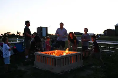 a group of people standing around a fire pit at Lodge 101 at Eden Reserve Near Ark in Williamstown