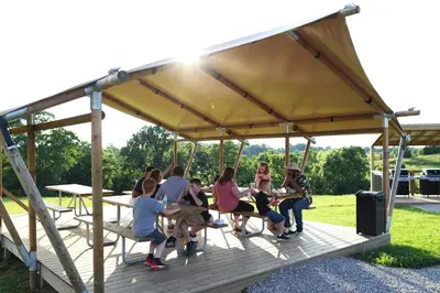 a group of people sitting in a gazebo at The Lodges at Eden Reserve - Pet Friendly Cabins Near Ark in Williamstown