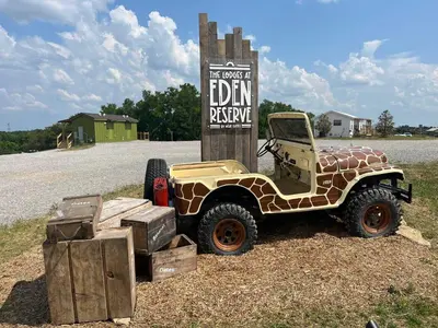 a jeep parked in front of a sign at The Lodges at Eden Reserve - Cabins Near Ark in Williamstown