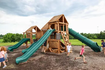 a group of children playing on a playground at The Lodges at Eden Reserve - Safari Tents in Williamstown