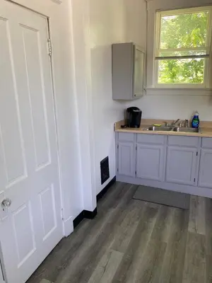 a kitchen with white cabinets and a sink and a window at Second floor petite studio private room in Cincinnati
