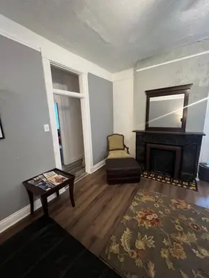 a living room with a fireplace and a chair at Second floor standard studio private room in Cincinnati