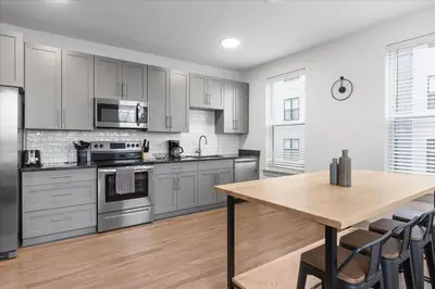 a kitchen with stainless steel appliances and a wooden table at 2 Stylish apartments near shops and entertainment in Cincinnati