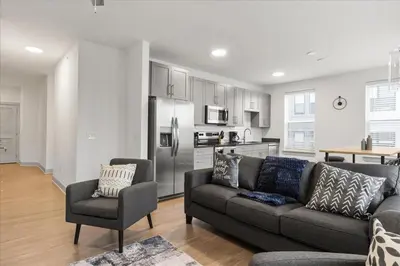 a living room with a couch and a kitchen at 2 Stylish apartments near shops and entertainment in Cincinnati