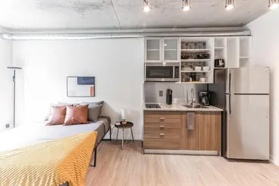 a bedroom with a bed and a kitchen with a refrigerator at 2 Studios apartment w prime location in Cleveland