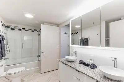 a white bathroom with two sinks and a shower at Centrally Located DT Luxury Apts at City Club in Cleveland