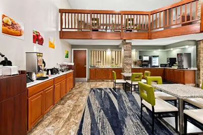 a lobby with a cafeteria with a table and chairs at Suburban Studios Mason Near Kings Island in Mason
