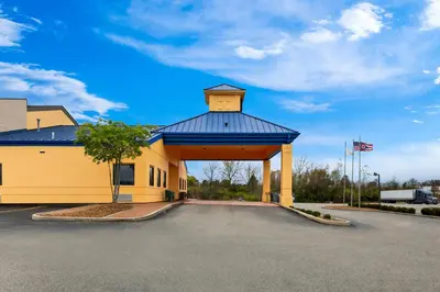 a large yellow building with a blue roof at Suburban Studios Mason Near Kings Island in Mason