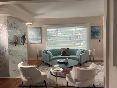 a living room with a blue couch and two chairs at Sunny Lavender Canopy Retreat in Cleveland