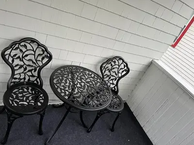 two chairs and a table sitting next to a wall at Garden Whisper Cozy Chamber in Cleveland