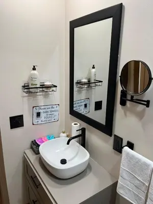 a bathroom with a white sink and a mirror at Elevated Entertainment Sleep Suite in Cleveland