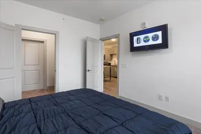 a bedroom with a bed and a tv on the wall at Stylish apartments near shops and entertainment in Cincinnati