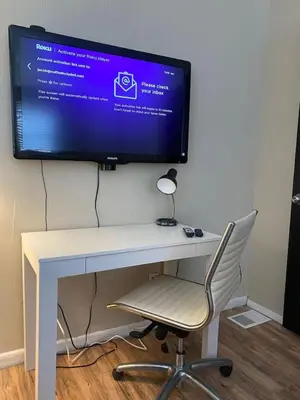 a computer monitor on a desk with a chair at Crew Housing Sleeps 8 with 6 Beds plus 4 Bedrooms in Dayton