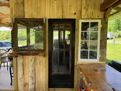 a wooden cabin with a door and windows on it at Cozy Cabin in New Lexington