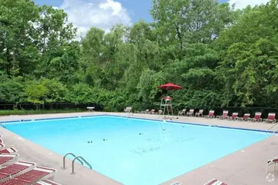 a large swimming pool with a red umbrella and chairs at Scenic towers 3012 I Cozy & Comfy I Free Parking in Parma