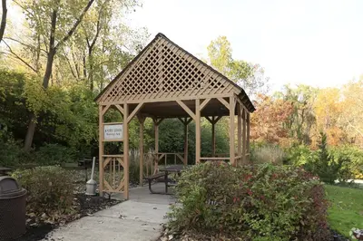 a wooden gazebo with a bench in a park at Midtown 3603 I Cozy & Comfy I Free Parking in Parma