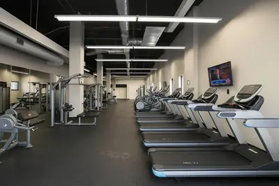 a gym with a row of treadmills and machines at Spacious Downtown Sq Stadium, Casino, R&R HoF in Cleveland