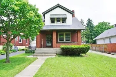 a red brick house with a tree in a yard at Cozy Bungalow Quiet Neighborhood Queen Bed Suite 3 10 Min to Downtown in Cincinnati
