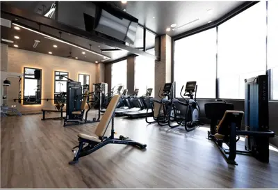 a gym with a bunch of treadms and ellipticals at Cozy 6BR 6BA combined Apartments Near Downtown Cincinnati in Cincinnati