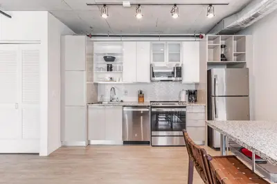 a kitchen with white cabinets and stainless steel appliances at 4 Brand new combined apartments with city views in Cleveland