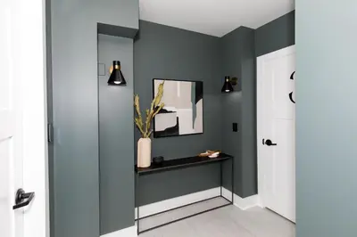 a hallway with green walls and a table and a mirror at Family Duplex Suite in Downtown Sandusky Sleeps 12! in Sandusky