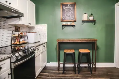 a kitchen with a table and two stools at Fauver Suite B in Dayton