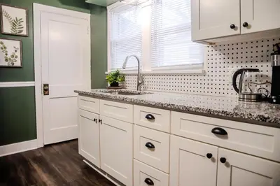 a kitchen with white cabinets and a sink at Fauver Suite B in Dayton